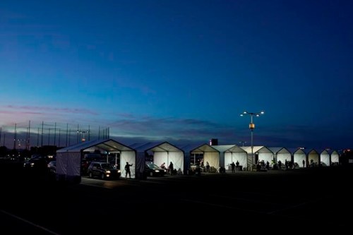 Several tents are set up so people who have registered can get their COVID-19 vaccinations as they drive-thru the parking lot of the State Farm Stadium, Tuesday, Jan. 12, 2021, in Glendale, Ariz. The Arizona Cardinals' stadium opened as a vaccination site Monday that will be a 24-7 operation. (AP Photo/Ross D. Franklin)