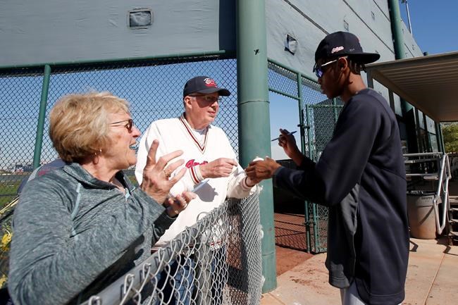 Cleveland Indians pitcher Triston McKenzie, right, gives autographs to fans during spring training baseball workouts for pitchers and catchers Friday, Feb. 14, 2020, in Avondale, Ariz. (AP Photo/Ross D. Franklin)