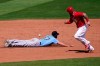 Cincinnati Reds' Tucker Barnhart, right, watches a single hit by Reds' Mark Payton get past Seattle Mariners third baseman Jantzen Witte (67) during the fifth inning of a spring training baseball game Monday, March 29, 2021, in Goodyear, Ariz. (AP Photo/Ross D. Franklin)