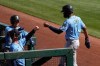 Seattle Mariners' Kyle Lewis (1) gets fist-bumps from manager Scott Servais, left, and a teammate as Lewis returns to the dugout after scoring against the Chicago White Sox during the third inning of a spring training baseball game Friday, March 5, 2021, in Phoenix. (AP Photo/Ross D. Franklin)