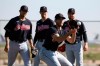Cleveland Indians pitcher Kyle Dowdy, front, fields a grounder as pitchers Carlos Carrasco, left, Shane Bieber, middle, and Logan Allen, right, look on during spring training baseball workouts for pitchers and catchers Thursday, Feb. 13, 2020, in Avondale, Ariz. (AP Photo/Ross D. Franklin)