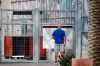 A ticket holder pauses outside a closed Goodyear Ballpark, spring training home of the Cleveland Indians and Cincinnati Reds baseball teams, reading a sign as to where he might get a refund for a canceled game, Thursday, March 12, 2020, in Goodyear, Ariz. Major League Baseball has suspended the rest of its spring training game schedule because if the coronavirus outbreak. MLB is also delaying the start of its regular season by at least two weeks. (AP Photo/Ross D. Franklin)