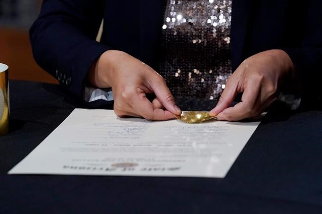 Arizona Election Services Director Bo Dul puts the official seal on the Arizona Presidential Electoral Ballot after members of Arizona's Electoral College signed the certificate Monday, Dec. 14, 2020, in Phoenix. (AP Photo/Ross D. Franklin, Pool)
