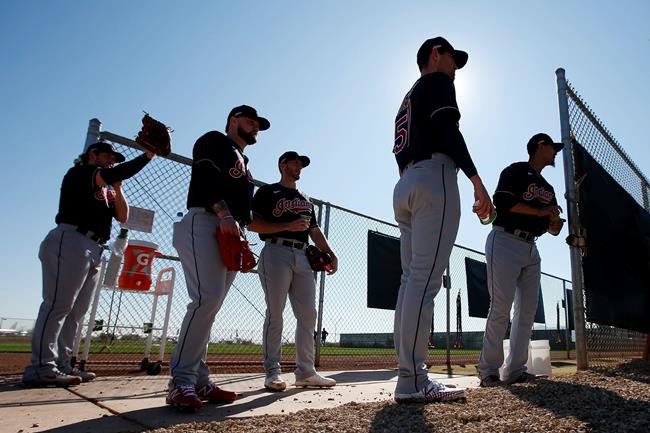 From left to right, Cleveland Indians pitchers Dominic Leone, Logan Allen, Kyle Dowdy, Shane Bieber, and Carlos Carrasco wait their turn for their pitching session during spring training baseball workouts for pitchers and catchers Thursday, Feb. 13, 2020, in Avondale, Ariz. (AP Photo/Ross D. Franklin)