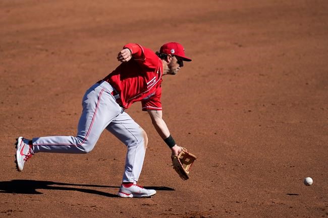 Cincinnati Reds shortstop Kyle Farmer reaches out to scoop up a grounder hit by Cleveland Indians' Billy Hamilton before throwing to first base for the out during the fourth inning of a spring training baseball game Sunday, Feb. 28, 2021, in Goodyear, Ariz. (AP Photo/Ross D. Franklin)