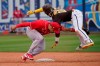 San Diego Padres' Jurickson Profar (10) tumbles over Cincinnati Reds shortstop Eugenio Suarez, left, after being tagged out on an attempted steal of second base in the fifth inning of a spring training baseball game Tuesday, March 23, 2021, in Peoria, Ariz. (AP Photo/Sue Ogrocki)