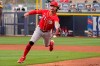 Cincinnati Reds second baseman Jonathan India fields a ground ball and flips it to first base for an out on San Diego Padres' Jake Cronenworth during the third inning of a spring training baseball game Tuesday, March 23, 2021, in Peoria, Ariz. (AP Photo/Sue Ogrocki)