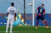 Real Madrid's goalkeeper Thibaut Courtois, background, stops a penalty kick by Levante's Roger Marti during the Spanish La Liga soccer match between Real Madrid and Levante at the Alfredo Di Stefano stadium in Madrid, Spain, Saturday, Jan. 30, 2021. (AP Photo/Manu Fernandez)