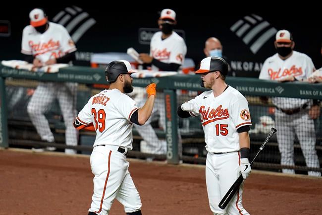 Baltimore Orioles' Renato Nunez, left, is greeted near the dugout by Chance Sisco after hitting a three-run home run off New York Mets starting pitcher Ariel Jurado during the first inning of a baseball game, Tuesday, Sept. 1, 2020, in Baltimore. Orioles' Cedric Mullins and Jose Iglesias scored on the home run. (AP Photo/Julio Cortez)