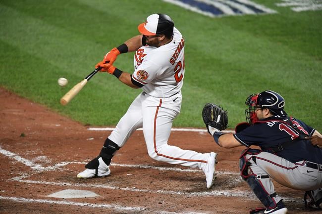 Baltimore Orioles' DJ Stewart, left, singles during the fifth inning of a baseball game against the Atlanta Braves, Monday, Sept. 14, 2020, in Baltimore. (AP Photo/Terrance Williams)