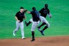 Miami Marlins shortstop Jonathan Villar (2) and center fielder Monte Harrison, right, celebrate after defeating the Baltimore Orioles 2-1 in the second game of a doubleheader, Wednesday, Aug. 5, 2020, in Baltimore. Marlins' Corey Dickerson, left, looks on. (AP Photo/Julio Cortez)