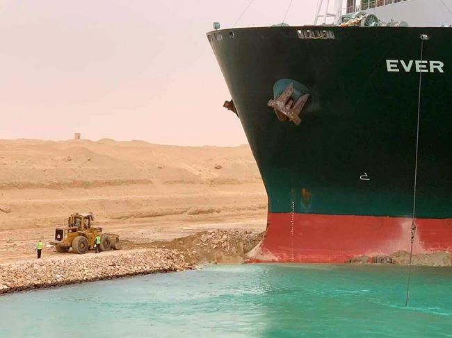 In this photo released by the Suez Canal Authority, a cargo ship, named the Ever Green, sits with its bow stuck into the wall Wednesday, March 24, 2021, after it turned sideways in Egypt’s Suez Canal, blocking traffic in a crucial East-West waterway for global shipping. An Egyptian official warned Wednesday it could take at least two days to clear the ship. (Suez Canal Authority via AP)