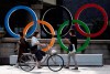In this July 15, 2021, file photo, people walk by the Olympic rings installed by the Nippon Bashi bridge in Tokyo. A Ugandan athlete who fled during his pre-game training in western Japan last week has been found and being interviewed by police, officials said Tuesday, July 20, 2021. (AP Photo/Hiro Komae, File)