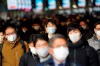 FILE - In this Jan. 4, 2021, file photo, people commute on the first business day of the year at a train station in Tokyo. Opposition to the Tokyo Olympics is growing with calls for a cancellation as virus cases rise in Japan. The International Olympic Committee and local organizers have already said another postponement is impossible, leaving cancellation, or going ahead, as the only options. (AP Photo/Eugene Hoshiko, File)
