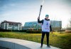 Nathanael Pianta poses with the Lausanne 2020 Youth Olympic Flame alongside the Olympic Rings outside Olympic House during the the final Torch Relay. The Winter Youth Olympic Games, Lausanne, Switzerland, Wednesday, Jan. 8, 2020. (Joel Marklund/Olympic Information Service via AP)