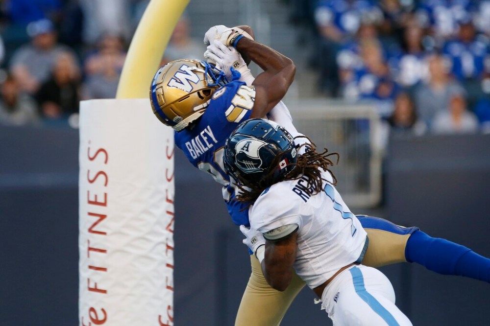 Winnipeg Blue Bombers' Rasheed Bailey makes a catch for a touchdown as Toronto Argonauts' Shaq Richardson defends during the first half. THE CANADIAN PRESS/John Woods