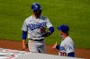Los Angeles Dodgers' Mookie Betts (50) gets a high-five from manager Joe Maddon, right, after scoring off of a line drive hit by Justin Turner during the fifth inning of a baseball game Saturday, May 8, 2021, in Anaheim, Calif. (AP Photo/Ashley Landis)