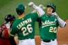 Oakland Athletics' Mark Canha, right, celebrates with Matt Chapman (26) after hitting a two run homerun off Arizona Diamondbacks pitcher Merrill Kelly in the third inning of a baseball game Wednesday, Aug. 19, 2020, in Oakland, Calif. (AP Photo/Ben Margot)