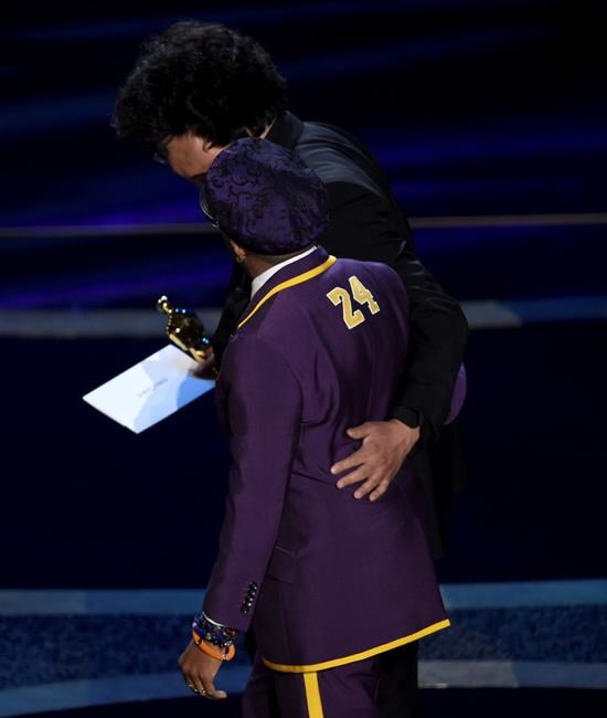 Presenter Spike Lee, foreground, and Bong Joon Ho walk off stage after accepting the award for best director for