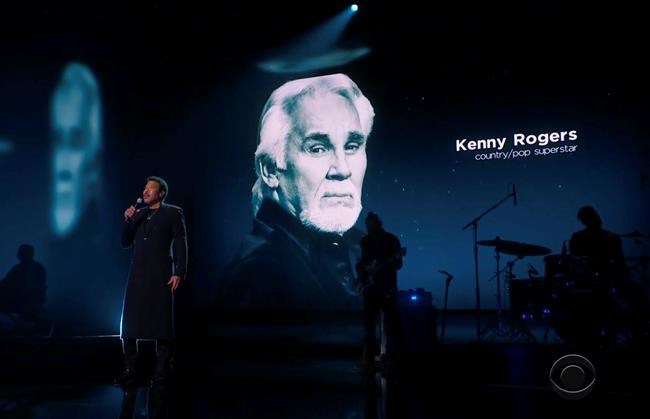 In this video grab provided by CBS and the Recording Academy, Lionel Richie performs during the In Memoriam as Kenny Rogers is pictured on screen at the 63rd annual Grammy Awards at the Los Angeles Convention Center on Sunday, March 14, 2021. (CBS/Recording Academy via AP)