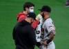 A trainer, top left, wipes Arizona Diamondbacks' Christian Walker's eye as manager Torey Lovullo looks on during the fourth inning of a baseball game against the San Diego Padres, Saturday, April 3, 2021, in San Diego. Walker was hit with the ball and was taken out of the game. (AP Photo/Denis Poroy)