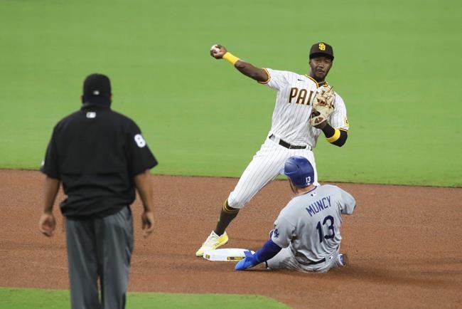 CORRECTS TO PADRES' JORGE MATEO NOT JURICKSON PROFAR - San Diego Padres second baseman Jorge Mateo, top right, attempts to turn a double play as Los Angeles Dodgers' Max Muncy, bottom right, slides into second in the fourth inning of a baseball game Monday, Sept. 14, 2020, in San Diego. Dodgers' Cody Bellinger was safe at first on the play. (AP Photo/Derrick Tuskan)