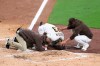 San Diego Padres manger Jayce Tingler, right, and a trainer, left, attend to Fernando Tatis Jr., center, after Tatis hurt his shoulder while swinging at a pitch in the third inning of a baseball game against the San Francisco Giants, Monday, April 5, 2021, in San Diego. (AP Photo/Derrick Tuskan)
