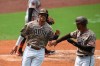 San Diego Padres third baseman Manny Machado high fives Trent Grisham after they score on a single to left field hit by Will Myers against the San Francisco Giants in the third inning of a baseball game Sunday, Sept. 13, 2020, in San Diego. (AP Photo/Derrick Tuskan)