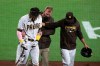 San Diego Padres manager Jayce Tingler, right, and a trainer help Fernando Tatis Jr, left, off the field after Tatis hurting his shoulder swinging at a pitch in the third inning of a baseball game against the San Francisco Giants, Monday, April 5, 2021, in San Diego. (AP Photo/Derrick Tuskan)