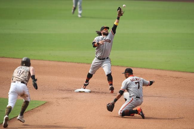 San Francisco Giants shortstop Brandon Crawford, top, cannot field a throw by Donovan Solano (7) on a ground ball hit by San Diego Padres' Greg Garcia in the sixth inning of a baseball game Sunday, Sept. 13, 2020, in San Diego. Austin Nola scored on the play while Croneworth was safe at second and advanced to third on the throwing error by Solano. (AP Photo/Derrick Tuskan)