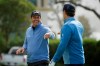 Phil Mickelson is greeted by Steve Young after chipping the ball into the 14th hole of the Pebble Beach Golf Links for a birdie during the third round of the AT&T Pebble Beach National Pro-Am golf tournament Saturday, Feb. 8, 2020, in Pebble Beach, Calif. (AP Photo/Eric Risberg)
