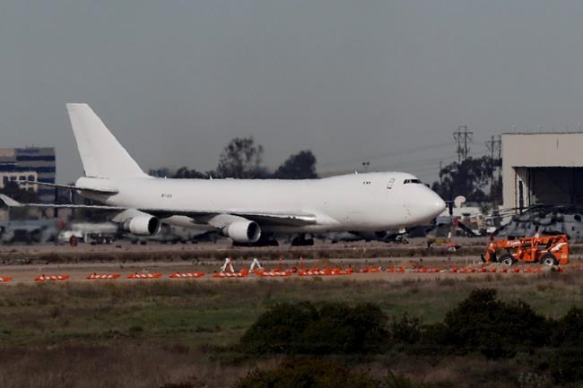A plane carrying evacuees from the virus zone in China lands at Marine Corps Air Station Miramar Wednesday, Feb. 5, 2020, in San Diego. One of two jets carrying Americans fleeing the virus zone in China landed Wednesday morning at Miramar after first landing at an Air Force base in Northern California. The passengers are scheduled to be quarantined at the Southern California military base, officials said. (AP Photo/Gregory Bull)