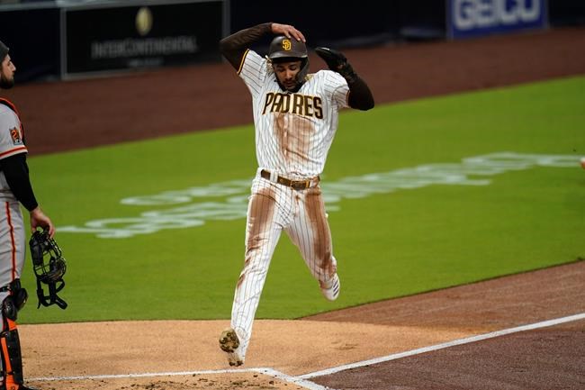 San Diego Padres' Fernando Tatis Jr. scores from second off a two-RBI double by Mitch Moreland during the first inning of a baseball game against the San Francisco Giants, Thursday, Sept. 10, 2020, in San Diego. (AP Photo/Gregory Bull)