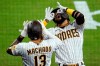 San Diego Padres' Fernando Tatis Jr., right, and Manny Machado (13) celebrate Tatis' home run during the fifth inning of a baseball game against the Los Angeles Dodgers, Friday, April 16, 2021, in San Diego. (AP Photo/Gregory Bull)
