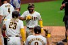San Diego Padres' Eric Hosmer, center, reacts with teammates after hitting a grand slam during the fifth inning of a baseball game against the Texas Rangers, Thursday, Aug. 20, 2020, in San Diego. (AP Photo/Gregory Bull)