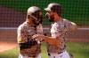 San Diego Padres' Eric Hosmer, right, reacts with teammate Fernando Tatis Jr after both scored off a two-RBI double by Tommy Pham during the eighth inning of a baseball game against the Los Angeles Dodgers, Sunday, April 18, 2021, in San Diego. (AP Photo/Gregory Bull)