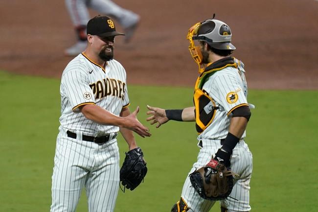 San Diego Padres relief pitcher Dan Altavilla, left, celebrates with catcher Austin Nola after the Padres defeated the San Francisco Giants 6-1 in a baseball game Thursday, Sept. 10, 2020, in San Diego. (AP Photo/Gregory Bull)