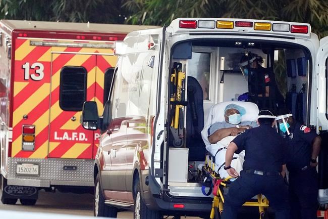 A patient is loaded onto an ambulance outside of the emergency entrance to PIH Health Good Samaritan Hospital Tuesday, Jan. 5, 2021, in Los Angeles. (AP Photo/Marcio Jose Sanchez)