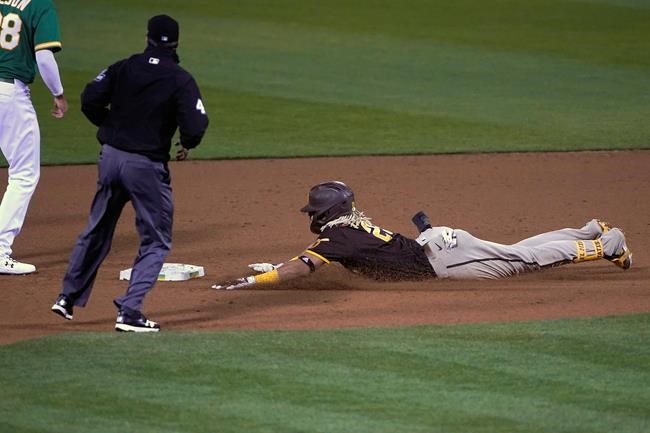 San Diego Padres' Fernando Tatis Jr., right, slides into second base on a double that scored two runs against the Oakland Athletics during the fifth inning of a baseball game in Oakland, Calif., Friday, Sept. 4, 2020. (AP Photo/Tony Avelar)