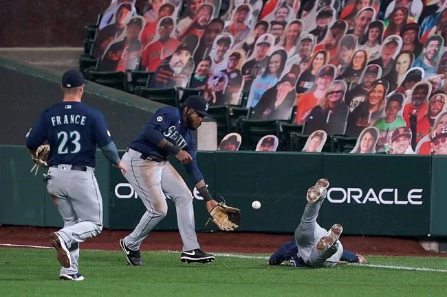 Seattle Mariners first baseman Evan White, right, dives for but can't make the catch on a double by San Francisco Giants' Wilmer Flores, as right fielder Phillip Ervin, center, and second baseman Ty France (23) come to assist during the fourth inning of a baseball game Wednesday, Sept. 9, 2020, in San Francisco. (AP Photo/Tony Avelar)