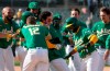Oakland Athletics' Ramon Laureano, center, celebrates with teammates after two runs scored on a throwing error by Minnesota Twins third baseman Luis Arraez during the 10th inning of a baseball game Wednesday, April 21, 2021, in Oakland, Calif. Laureano safe at first. Oakland won 13-12. (AP Photo/Tony Avelar)