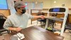 The robot server at Hong Du Kkae restaurant in Winnipeg delivers a meal to diner Andrew Zhang. (Trevor Brine / CBC)