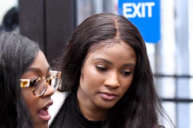 FILE - In this Feb. 23, 2019, photo, Joycelyn Savage, right, a girlfriend of R. Kelly, leaves the Leighton Criminal Courthouse in Chicago following the R&B star's first court appearance on sexual abuse charges. Chicago police said Thursday, Jan. 9, 2020, that Savage was taken into custody Wednesday, Jan. 8 after allegedly punching another girlfriend of R. Kelly's in the face inside the embattled singer's Trump Tower condominium. Savage was charged with misdemeanor domestic battery. (AP Photo/Matt Marton, File)
