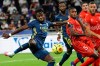 Lyon's Maxwel Cornet, left, kicks the ball during the French League One soccer match between Lyon and Nimes in Decines, near Lyon, central France, Friday, Sept. 18, 2020. (AP Photo/Laurent Cipriani)