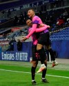 Paris Saint Germain's Kylian Mbappe, right, celebrates with Abdou Diallo after he scored a goal against Lyon during the French League One soccer match between Lyon and PSG in Decines, near Lyon, central France, Sunday, March 21, 2021. (AP Photo/Laurent Cipriani)