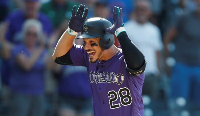 FILE In this Aug. 14, 2019, file photo, Colorado Rockies' Nolan Arenado celebrates as he circles the bases after hitting a walkoff, two-run home run off Arizona Diamondbacks relief pitcher Archie Bradley in the ninth inning of a baseball game in Denver. Arenado is at odds with the team's front office as the Rockies head to spring training for the season ahead. (AP Photo/David Zalubowski, File)