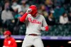 Philadelphia Phillies' Rhys Hoskins taps his helmet as he crosses home plate after hitting a three-run home run off Colorado Rockies relief pitcher Jhoulys Chacin during the sixth inning of a baseball game Saturday, April 24, 2021, in Denver. (AP Photo/David Zalubowski)