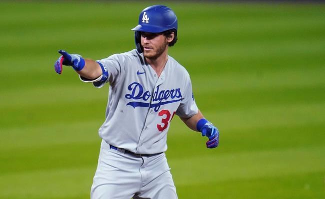 Los Angeles Dodgers' Cody Bellinger gestures to the dugout after pulling into second base with a double off Colorado Rockies relief pitcher Wade Davis to lead off seventh inning of a baseball game Friday, Sept. 18, 2020, in Denver. The Dodgers won 15-6. (AP Photo/David Zalubowski)