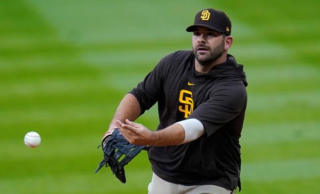 Newly-acquired San Diego Padres first baseman Mitch Morteland warms up before a baseball game against the Colorado Rockies, Monday, Aug. 31, 2020, in Denver. Moreland comes to San Diego from the Boston Red Sox. (AP Photo/David Zalubowski)