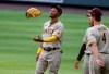 San Diego Padres left fielder Edward Olivares, left, tosses his glove in the air while chatting with center fielder Trent Grisham, center, and San Diego Padres right fielder Wil Myers during a pitching change in the second inning of a baseball game against the Colorado Rockies on Saturday, Aug. 1, 2020, in Denver. (AP Photo/David Zalubowski)